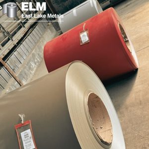Close-up of high-grade architectural metal coils in an industrial warehouse, showcasing the benefits of aluminum and steel substrates in various factory-applied colors for East Lake Metals building envelope solutions.