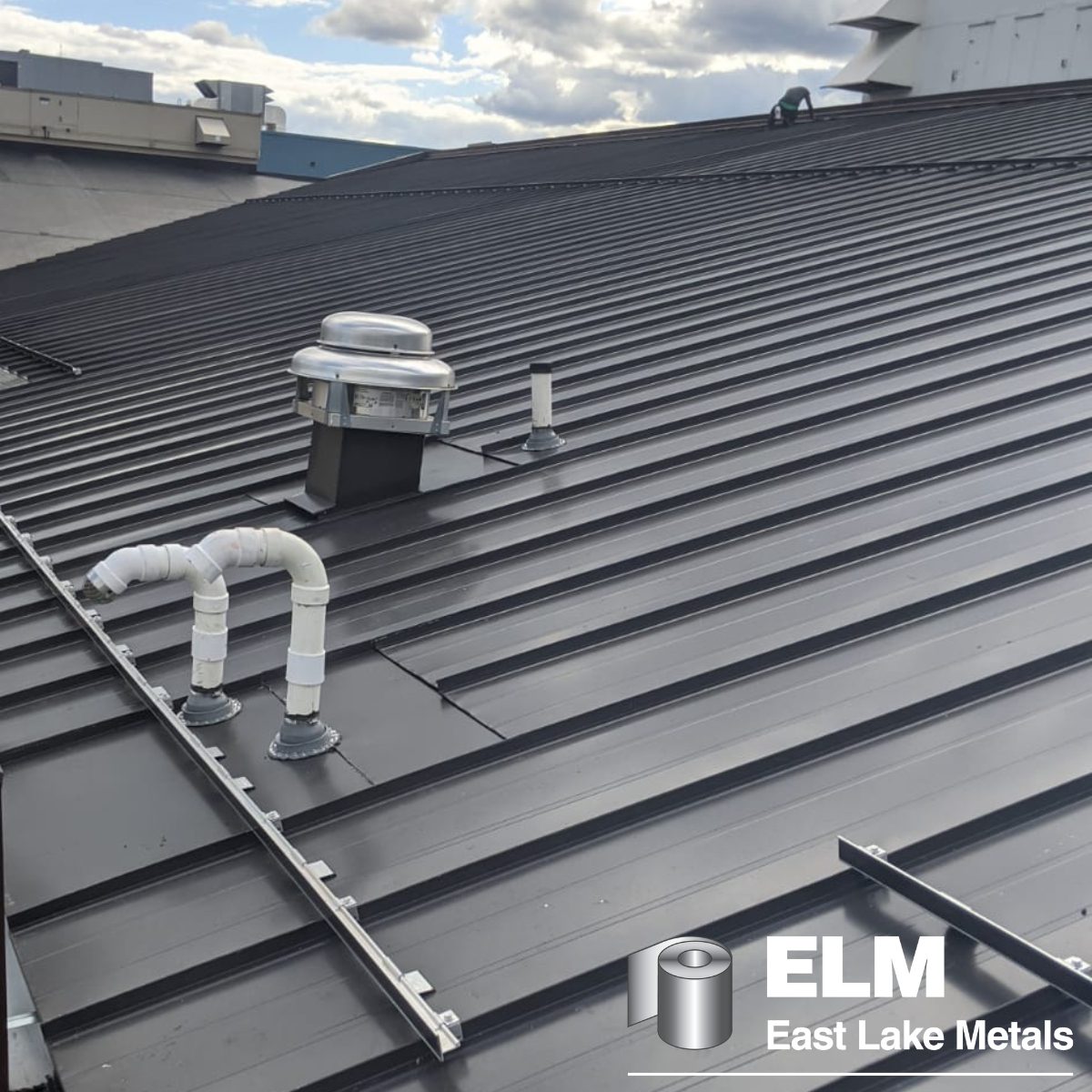 A technical view of a large-scale industrial roof with complex penetrations, protected by charcoal grey PVDF coatings for construction projects supplied by East Lake Metals.