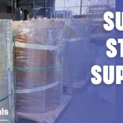 East Lake Metals banner titled "SUPPLYING STRENGTH, SUPPORTING SUCCESS," featuring high-capacity steel coils wrapped for transport in a warehouse to demonstrate their role as a trusted metal supplier for industrial manufacturing.